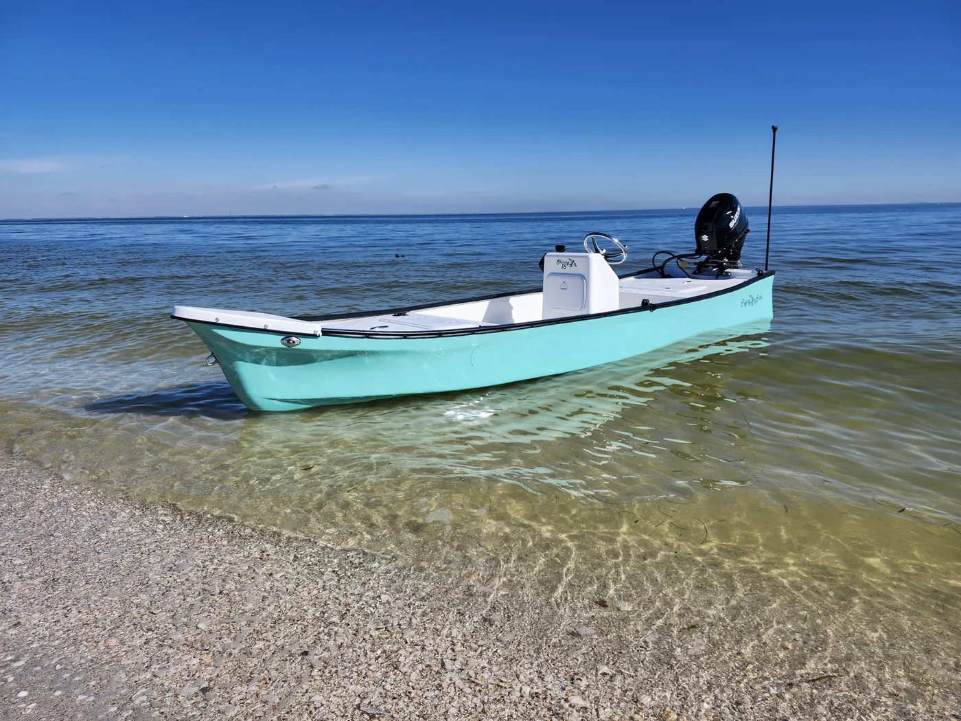 Flying Fish Skiffs seafoam 16′1″ shallow-water skiff beached in crystal-clear water