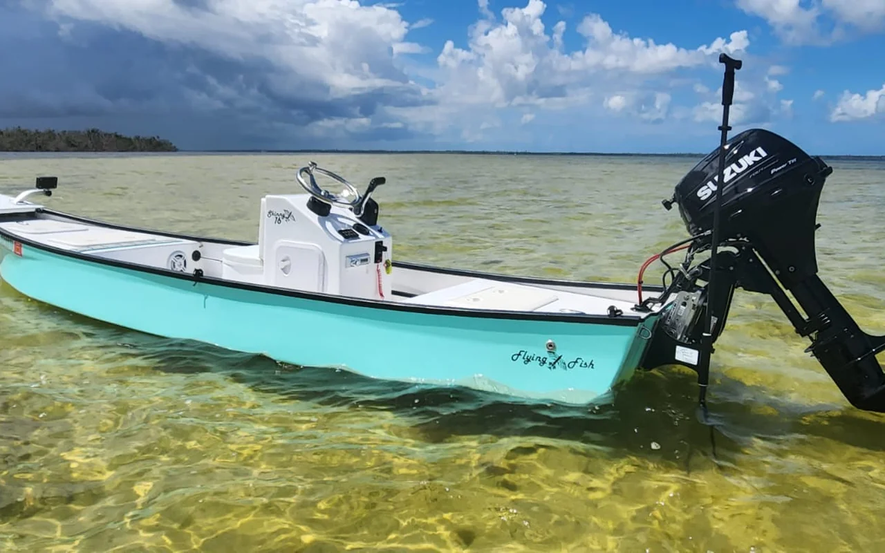 Flying Fish Skiffs seafoam shallow-water skiff in skinny flats water under dramatic sky